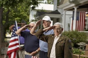 Senior veterans at a bbq salute.