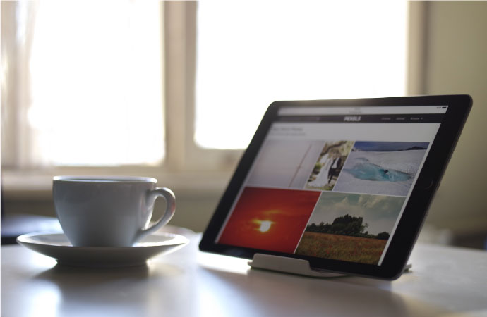Smart home tablet device on the table next to cup of tea