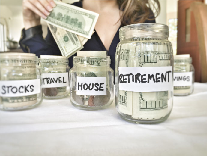 Woman putting money into personal finance jars for retirement and savings