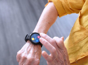 elderly woman wearing sos smartwatch and pressing touchscreen